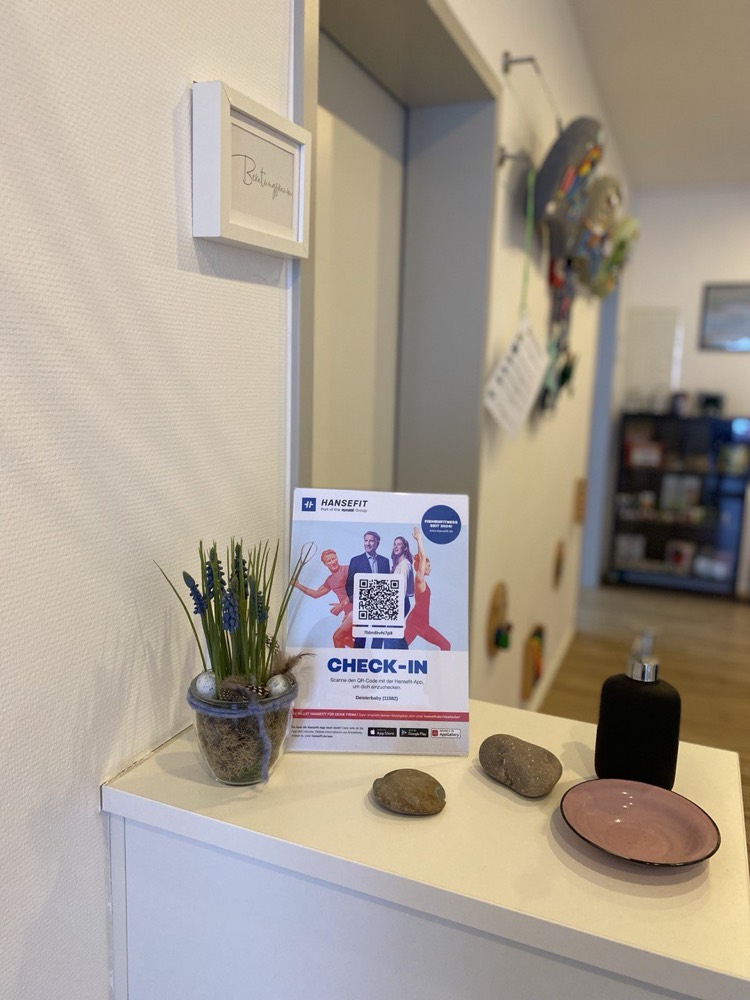 Aufsteller zum Einchecken mit der App (damals noch HanseFit, heute Epassi) im Flur der Praxis Miteinander am Deister